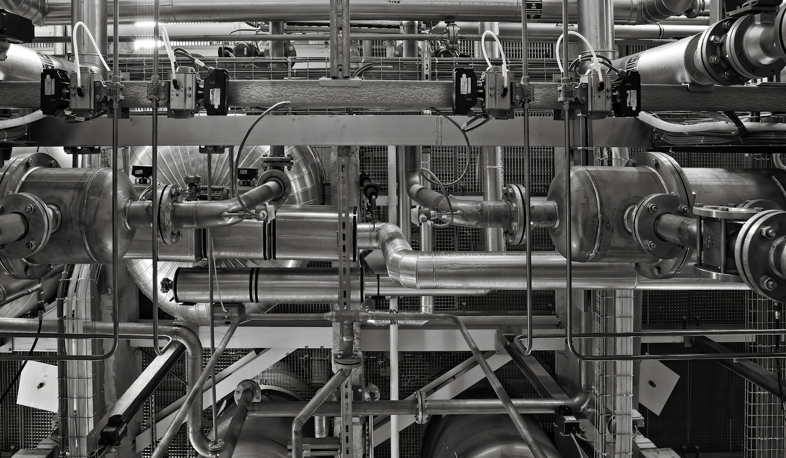 A PrimeFix engineer inspecting pipework in a commercial plant room.